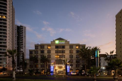 a hotel with a green sign on top of it at Holiday Inn Express - Iquique by IHG in Iquique