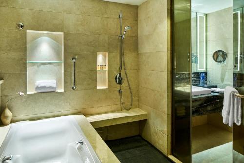 a bathroom with a tub and a shower and a sink at Crowne Plaza Xi'an by IHG in Xi'an