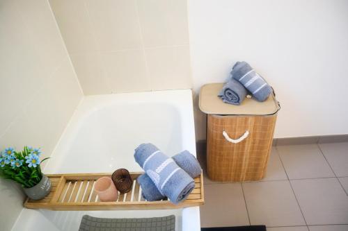 une salle de bain avec des serviettes sur une étagère à côté d'une poubelle dans l'établissement Appartement à 5 min de Disneyland Paris idéal pour familles et couples, à Bussy-Saint-Georges