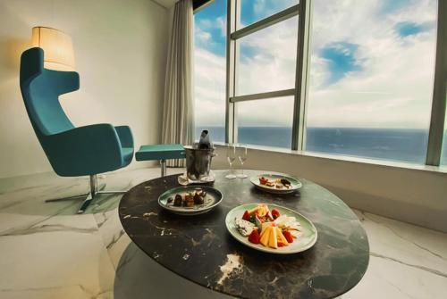 a table with two plates of food on it in front of a window at Hotel Nacional Rio de Janeiro - OFICIAL in Rio de Janeiro