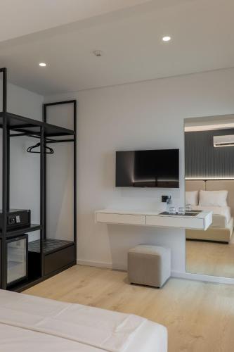 a living room with a bed and a tv at Arrei Hotel in Sarandë