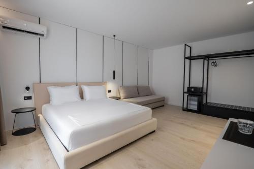a bedroom with a white bed and a couch at Arrei Hotel in Sarandë