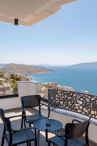 a balcony with chairs and tables and a view of the ocean at Arrei Hotel in Sarandë