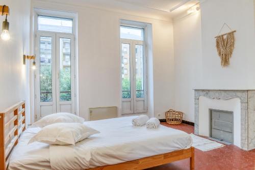 - une chambre blanche avec 2 lits et une cheminée dans l'établissement Bright And Spacious Apartment, Near Vieux Port & Endoume, à Marseille