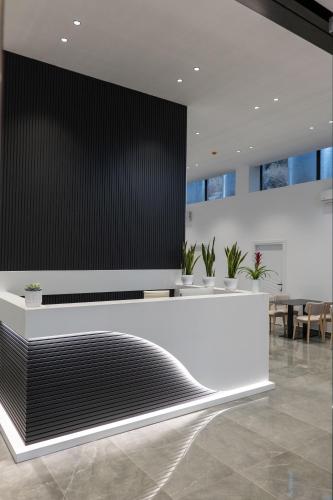a lobby with a black and white reception desk at Arrei Hotel in Sarandë