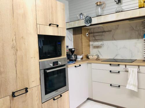 a kitchen with white cabinets and a microwave at Casa Scaglione in Porticcio