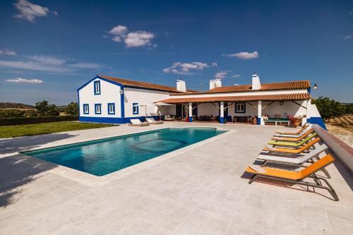 a villa with a swimming pool and a house at Monte do Melo in Montemor-o-Novo