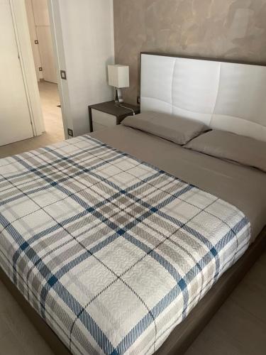 a bed with a blue and white blanket on it at Casa Regina in Civitanova Marche