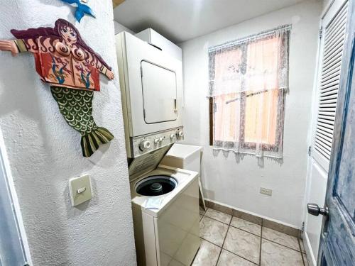 a bathroom with a washing machine and a sink at Sandy Beach Princesa D107 Ocean Front Resort in Puerto Peñasco