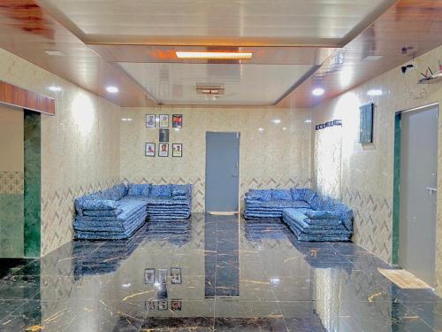 um átrio com sofás azuis num quarto em Military Farmhouse resort em Badlapur