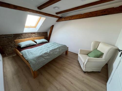 a bedroom with a bed and a chair at Apartmán Masarykovo náměstí in Děčín
