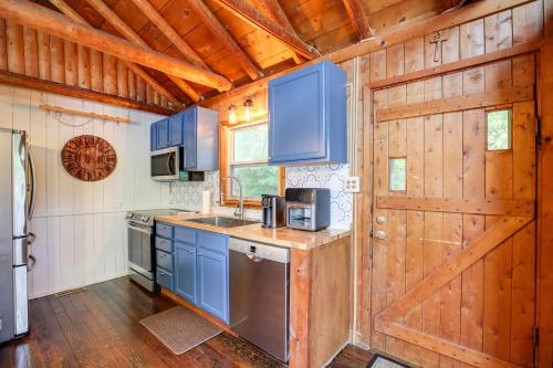 a kitchen with blue cabinets and a wooden door at Lakefront Lusby Home with Fire Pit 3 Mi to Beach! in Lusby