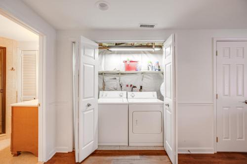 a white bathroom with a sink and a mirror at Lakefront Lusby Home with Fire Pit 3 Mi to Beach! in Lusby