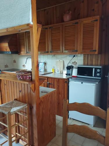 une cuisine avec des armoires en bois et un four à plaques de cuisson dans l'établissement Maison d'hôtes de charme indépendante proche RER B, à Aulnay-sous-Bois