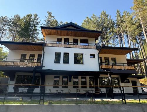 a large white building with a balcony at Vila Aspen - Mountain View Apartments in Delčevo