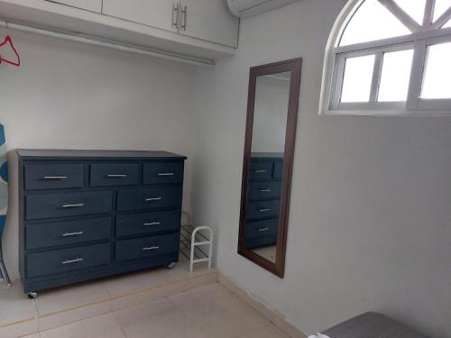 a bedroom with a dresser and a mirror at Serenity Home Hospedaje con confort y seguridad in Mérida