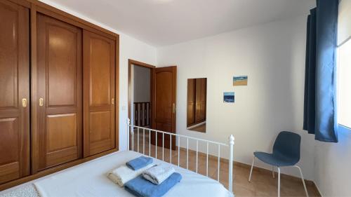 ein Schlafzimmer mit einem Bett und einem Stuhl darin in der Unterkunft Casa Angela in Corralejo