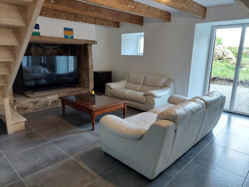 un salon avec un canapé, une table et une télévision dans l'établissement Les Gîtes de Kerhuon, à Audierne