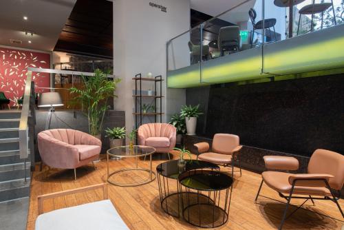 a waiting room with pink chairs and tables at Crowne Plaza Lima by IHG in Lima