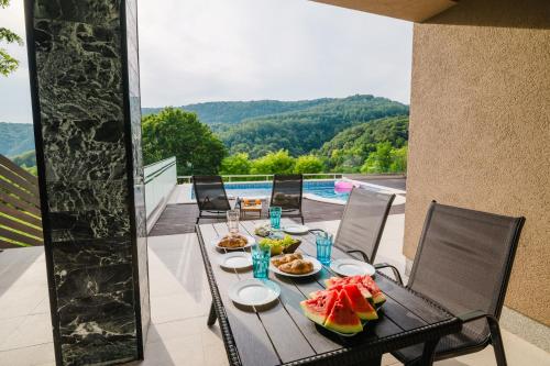 a table with food on a balcony with a pool at Čarobni pogled Zagreb in Zagreb