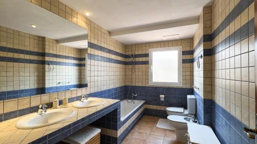 ein Badezimmer mit zwei Waschbecken und einer Badewanne und einer Toilette in der Unterkunft Casa Angela in Corralejo