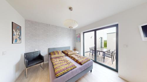 a bedroom with a bed and a chair and a table at Ruhige komplette Wohnung voll Ausgestattet 35min Bahn bis München in Reichertshausen