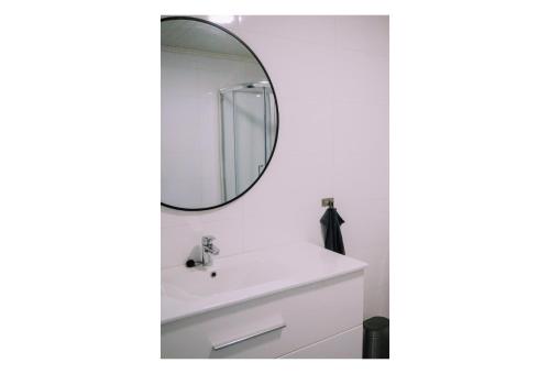 a bathroom with a white sink and a mirror at Valldal Sentrum Overnatting in Valldal