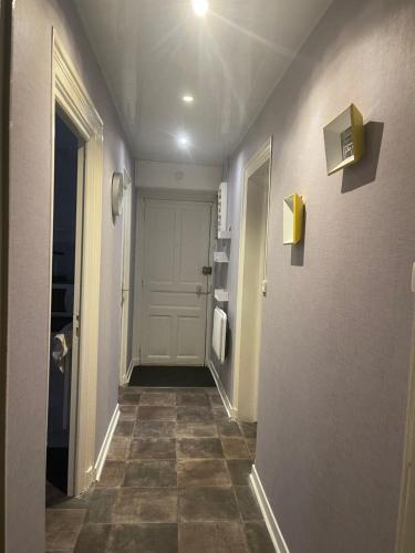 un couloir d'une salle de bains avec une porte et du carrelage. dans l'établissement La Belle Évasion, à Clermont-Ferrand