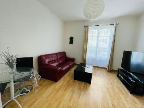 un salon avec un canapé en cuir et une télévision dans l'établissement La Belle Évasion, à Clermont-Ferrand
