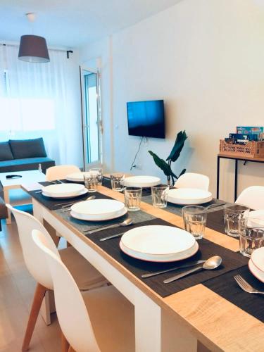 a dining room table with white plates and chairs at Chalet con JARDIN PUY DU FOU a 10 min ,NO FIESTAS!! in Toledo