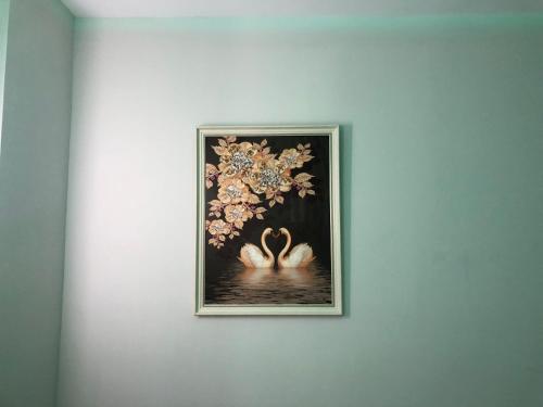a framed picture of two swans in the water at Suite In City Center in Tirana