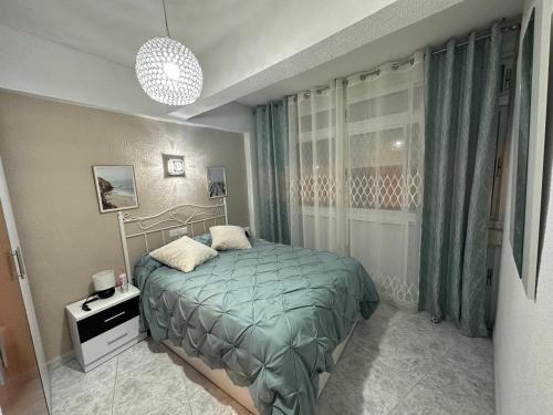 a bedroom with a bed and a chandelier at Apartamento en Paseo Larios de Torre del mar in Torre del Mar