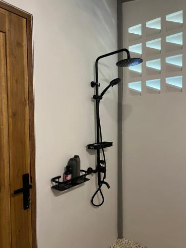 a black lamp on a wall next to a door at Liontree Villa in Kolongan