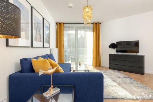 a blue couch in a living room with a table at Prestige 103 - z widokiem na morze - BASEN, sauna, jacuzzi w cenie pobytu! - Easy - Rent Apartments in Pobierowo