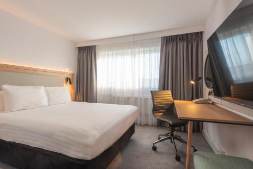 a hotel room with a bed and a desk at Holiday Inn Edinburgh Zoo by IHG in Edinburgh