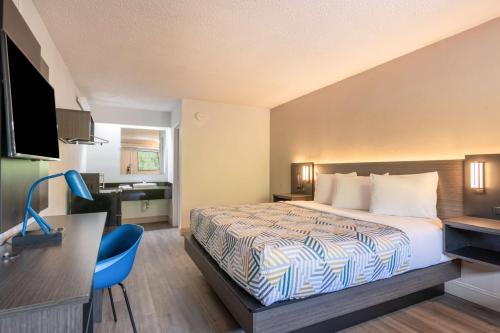 a hotel room with a bed and a desk at Motel 6-Charlotte, NC - Coliseum in Charlotte