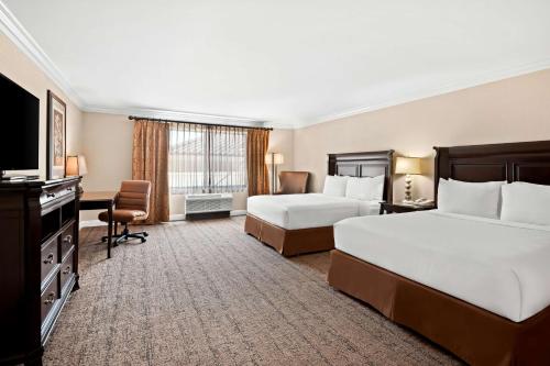 a hotel room with two beds and a flat screen tv at Best Western Ontario Mills Mall in Ontario