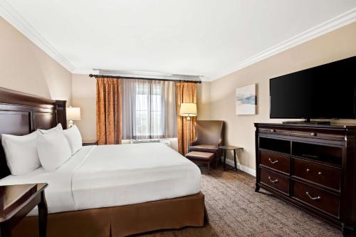 a hotel room with a bed and a flat screen tv at Best Western Ontario Mills Mall in Ontario