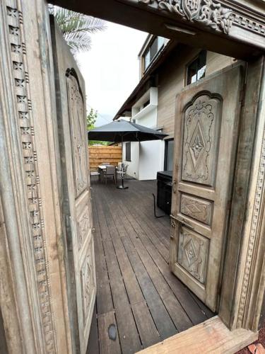 an open door to a patio with an umbrella at Appartement Jacuzzi - Tec-Tec 1 in Trois Bassins
