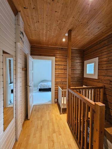 a room with a staircase in a wooden house at Rauhallinen asunto maalla, navetan päädyssä. in Muurame
