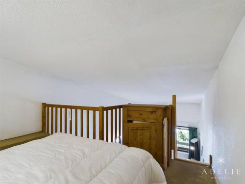 une chambre avec un lit blanc et une fenêtre dans l'établissement Studio mezzanine rénové 26m², au pied des pistes, balcon, 4 pers, proche commerces et garderie - FR-1-398-497, à La Rosière