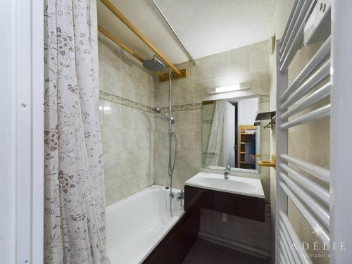 une salle de bain avec une baignoire et un lavabo dans l'établissement Studio mezzanine rénové 26m², au pied des pistes, balcon, 4 pers, proche commerces et garderie - FR-1-398-497, à La Rosière