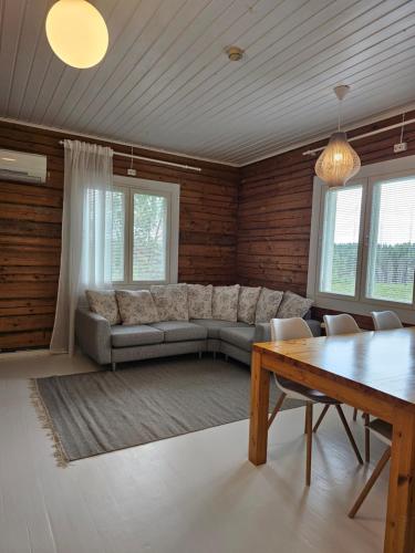 a living room with a couch and a table at Rauhallinen asunto maalla, navetan päädyssä. in Muurame