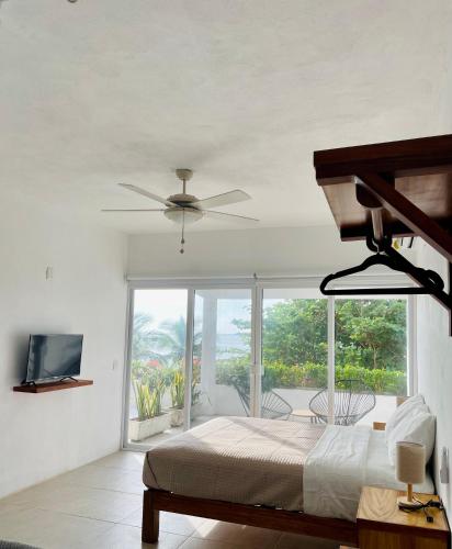 a bedroom with a bed and a ceiling fan at Casa A la Mar in Zihuatanejo