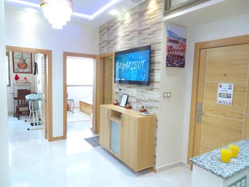 a living room with a tv on a brick wall at Paradise House Apartment in Tamraght in Tamraght Ouzdar