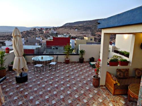 a patio with a table and chairs on a balcony at Paradise House Apartment in Tamraght in Tamraght Ouzdar