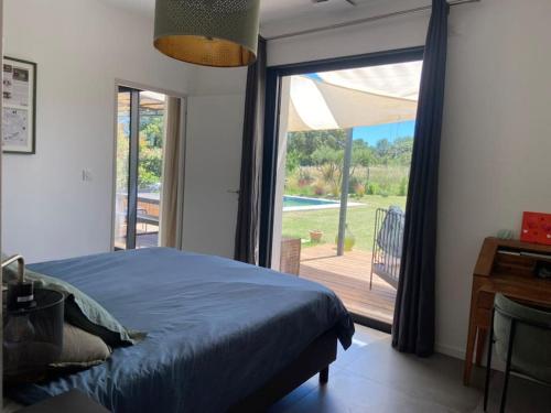 une chambre avec un lit et une porte coulissante en verre dans l'établissement Villa familiale avec piscine, à Assas