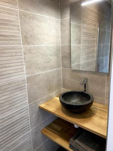 une salle de bain avec un lavabo noir et un miroir dans l'établissement Villa familiale avec piscine, à Assas