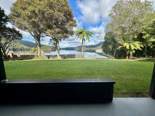 a window view of a park with a view of the water at Lakes Lodge Okataina in Rotorua