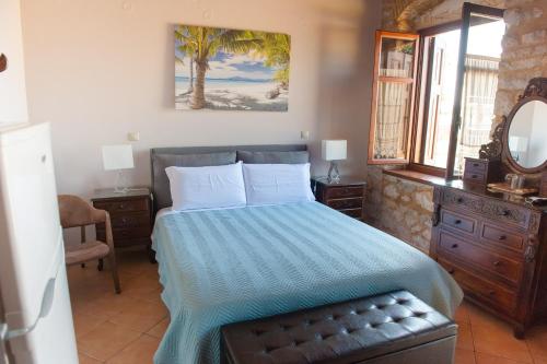 a bedroom with a bed with a blue comforter at SeaFront Stone Suites in Vonitsa